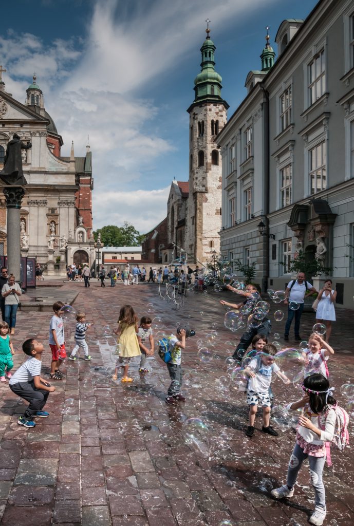 Dzieci bawiące się bańkami mydlanymi na ulicy Grodzkiej